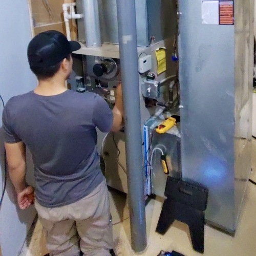 Technician maintains a heater.